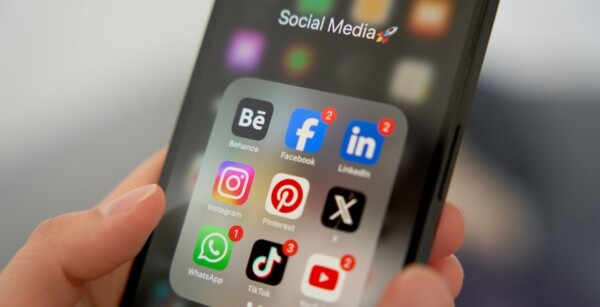 a person holding a phone with a bunch of apps on the screen