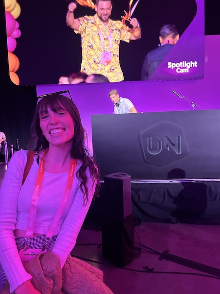 Jordan smiling in front of a stage at Hubspot Unbound